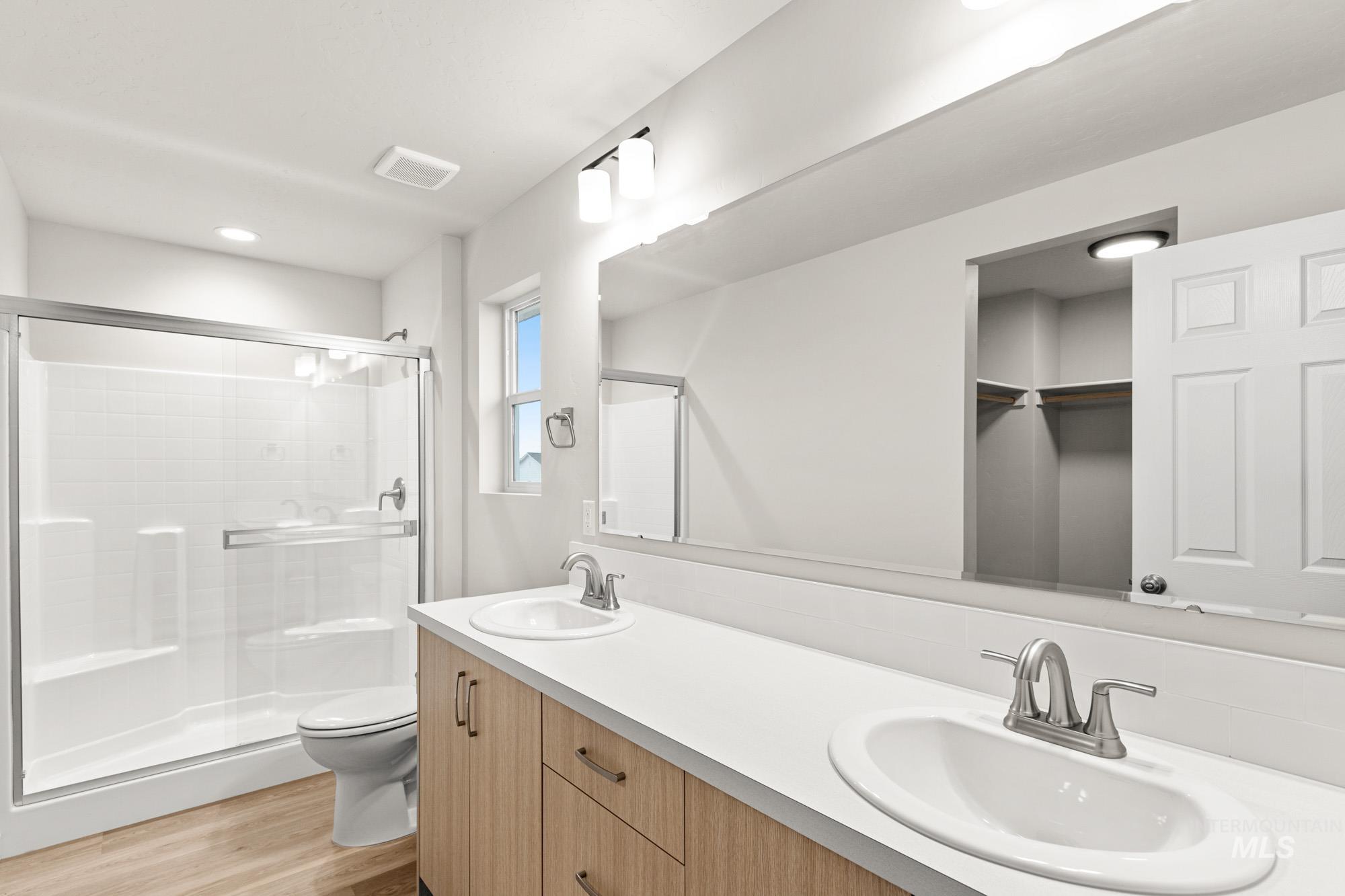 13711 Inman Court Caldwell, ID 83607 - Photo 15 of 16 Full bath with double vanity, a shower stall, light wood-style floors, a spacious closet, and recessed lighting