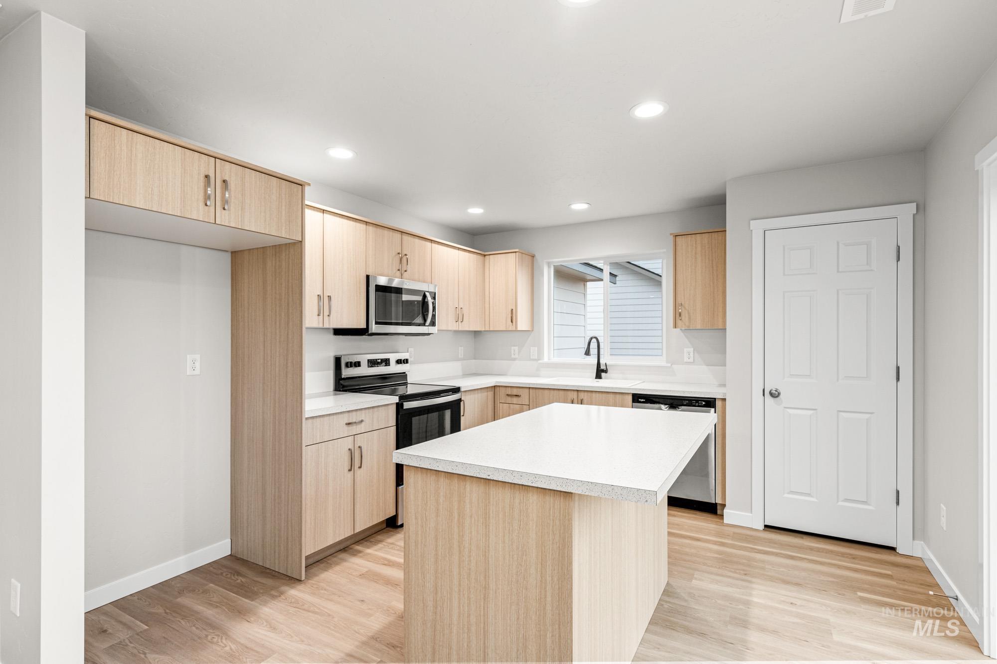 13711 Inman Court Caldwell, ID 83607 - Photo 3 of 16 Kitchen featuring light wood finish cabinetry, stainless steel appliances, light countertops, light wood finished floors, and recessed lighting