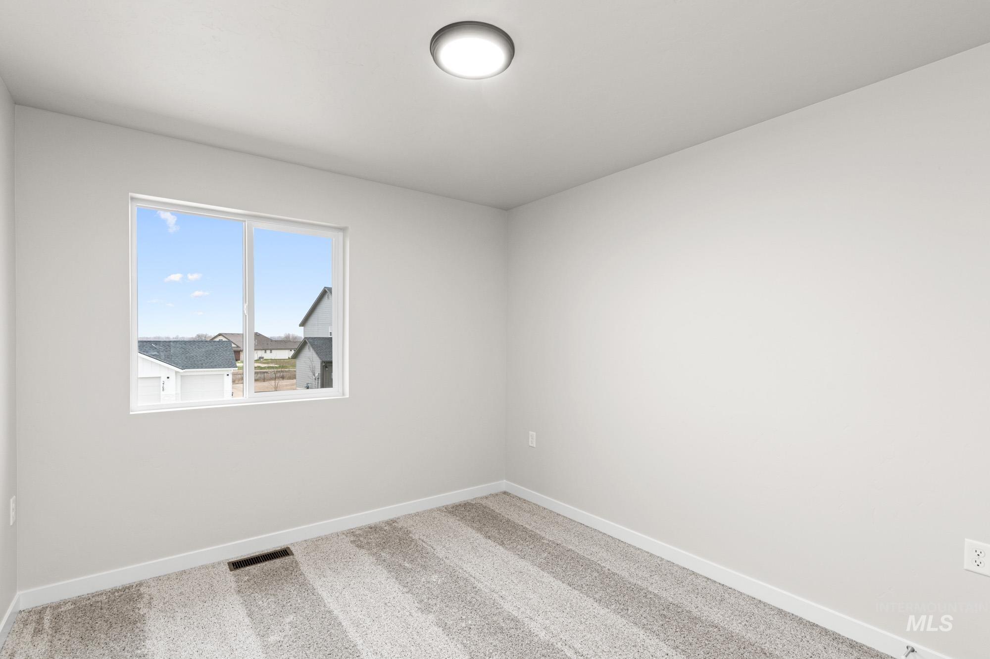13711 Inman Court Caldwell, ID 83607 - Photo 9 of 16 Empty room with carpet flooring and baseboards