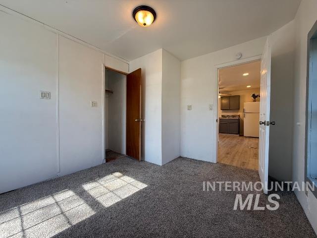 902 East Main Street Weiser, ID 83672 - Photo 20 of 45 Unfurnished bedroom with freestanding refrigerator and light colored carpet