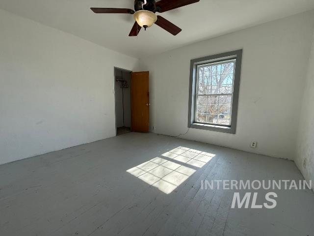 902 East Main Street Weiser, ID 83672 - Photo 22 of 45 Unfurnished bedroom with a ceiling fan, wood-type flooring, and a closet