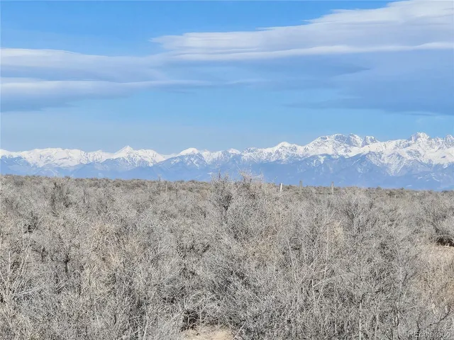a view of a large mountain with mountains in the background
