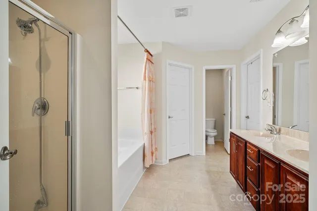 a bedroom with a large bed and a potted plant