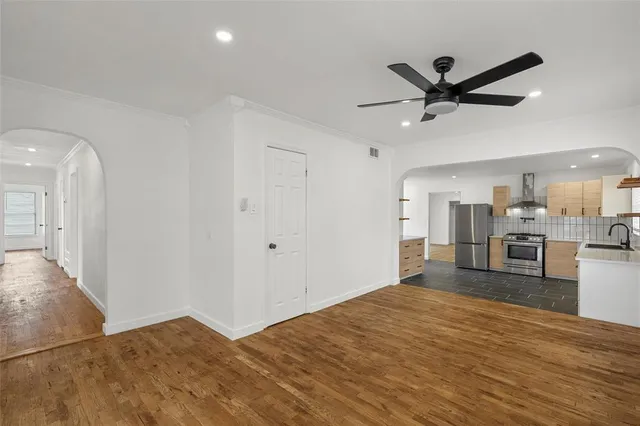 a view of a kitchen with a sink and dishwasher a refrigerator with wooden floor