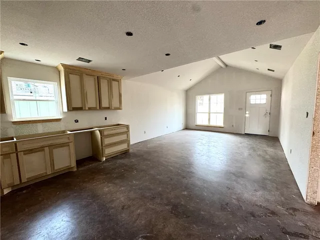 a large white kitchen with a sink and dishwasher a stove top oven with wooden floor