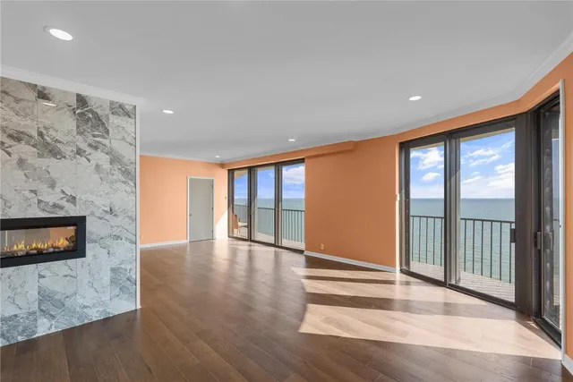 a view of an empty room with wooden floor and a chair