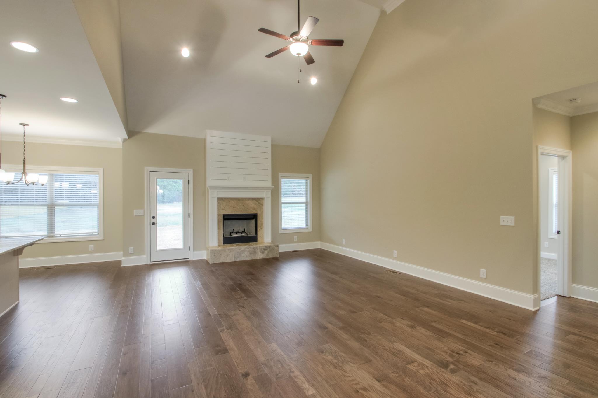 2305 Cairo Bend Road Lebanon, TN 37087 - Photo 14 of 30 an empty room with wooden floor a ceiling fan and windows