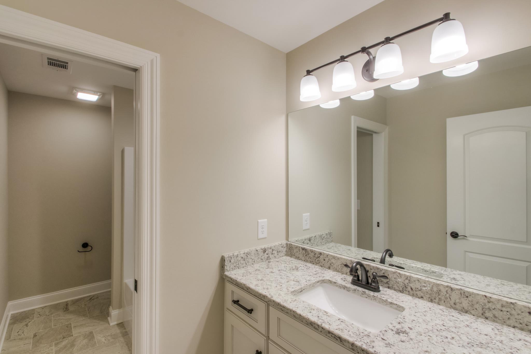 2305 Cairo Bend Road Lebanon, TN 37087 - Photo 24 of 30 a bathroom with a granite countertop sink a mirror and a shower