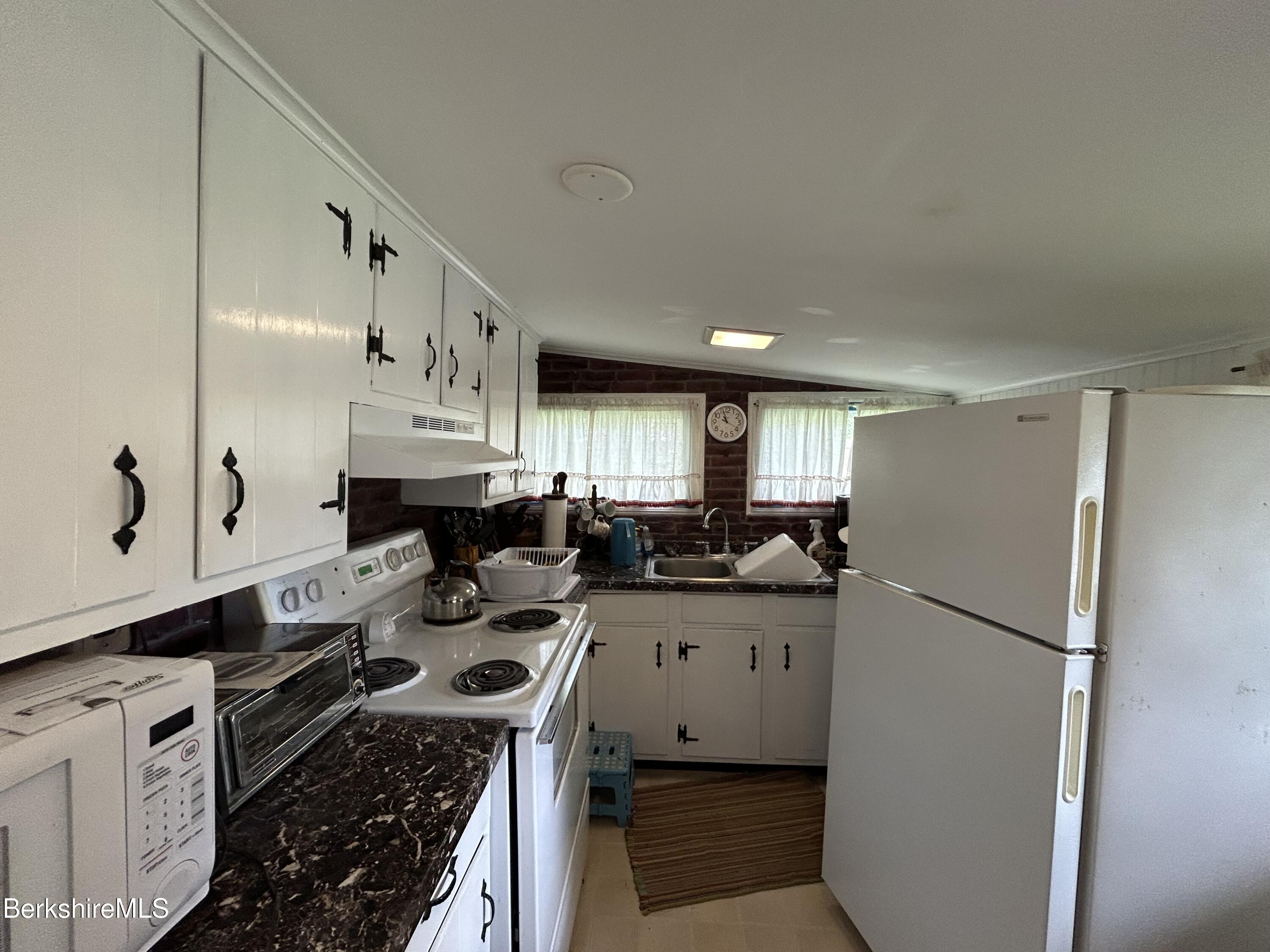 369 Pine Road Otis, MA 01029 - Photo 8 of 12 a kitchen with refrigerator a stove a sink and cabinets