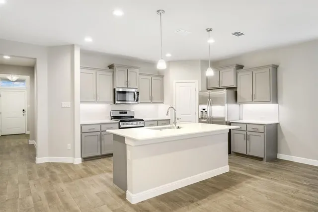 a kitchen with kitchen island a sink stainless steel appliances and cabinets