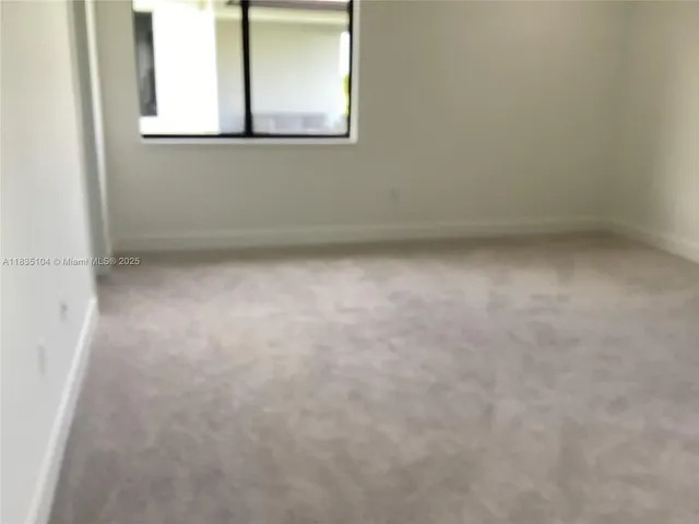 a view of a small space with wooden floor and a window