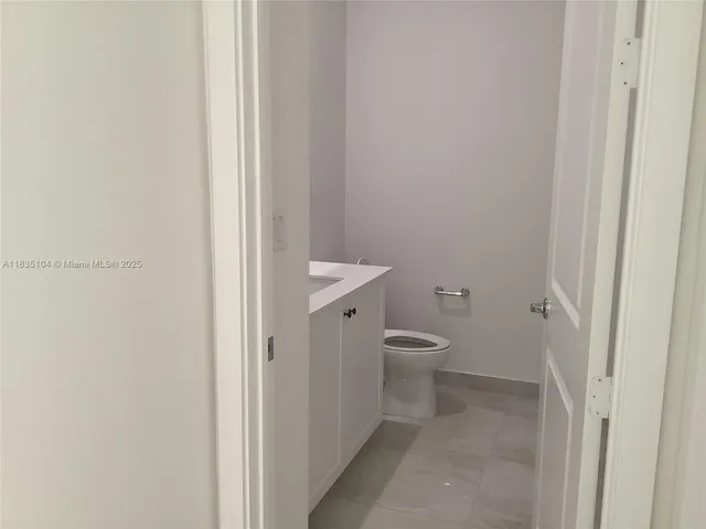 a bathroom with a granite countertop toilet and a sink