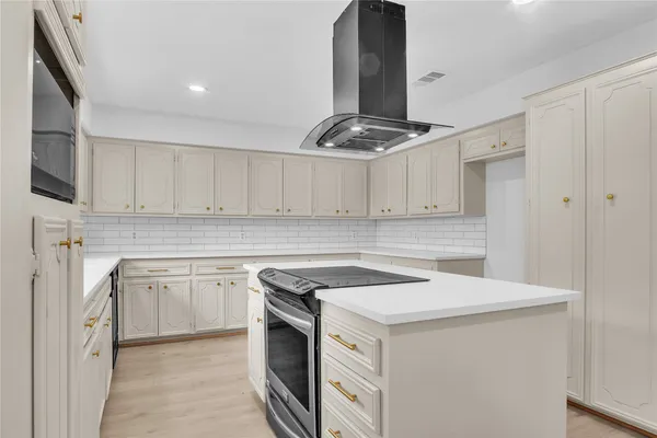 a kitchen with a stove a refrigerator and a microwave