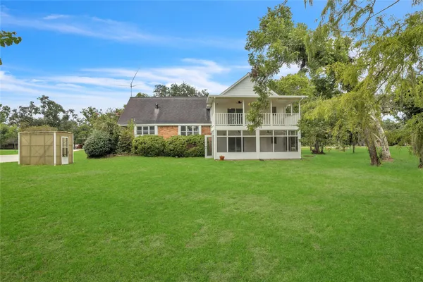 an aerial view of residential house with outdoor space and trees all around
