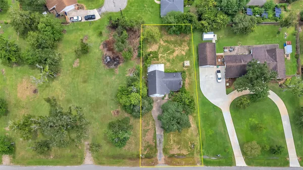an aerial view of residential houses with outdoor space and trees