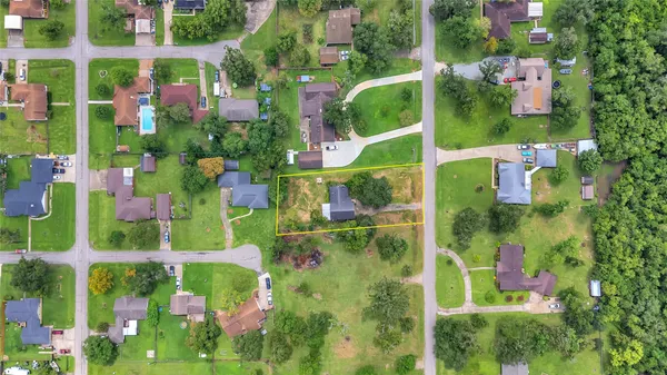 an aerial view of residential houses with outdoor space and trees
