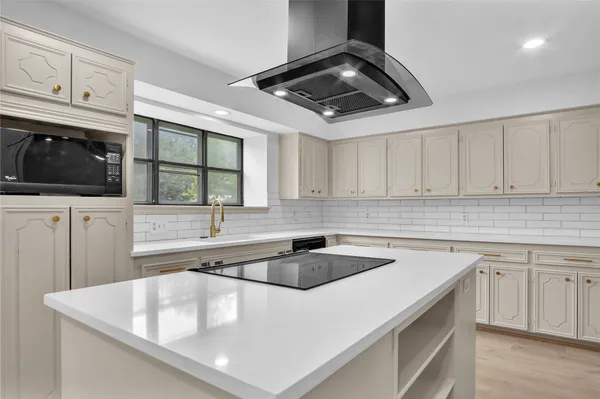 a kitchen with granite countertop a sink stainless steel appliances and white cabinets
