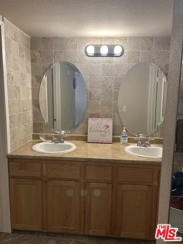 a bathroom with a double vanity sink and a mirror