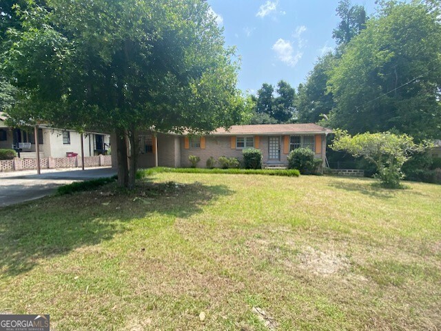 a view of a house with a yard and sitting area