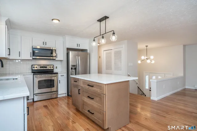 a kitchen with stainless steel appliances a stove top oven and refrigerator