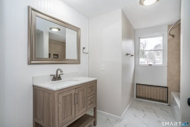 a bathroom with a toilet a sink a vanity and mirror