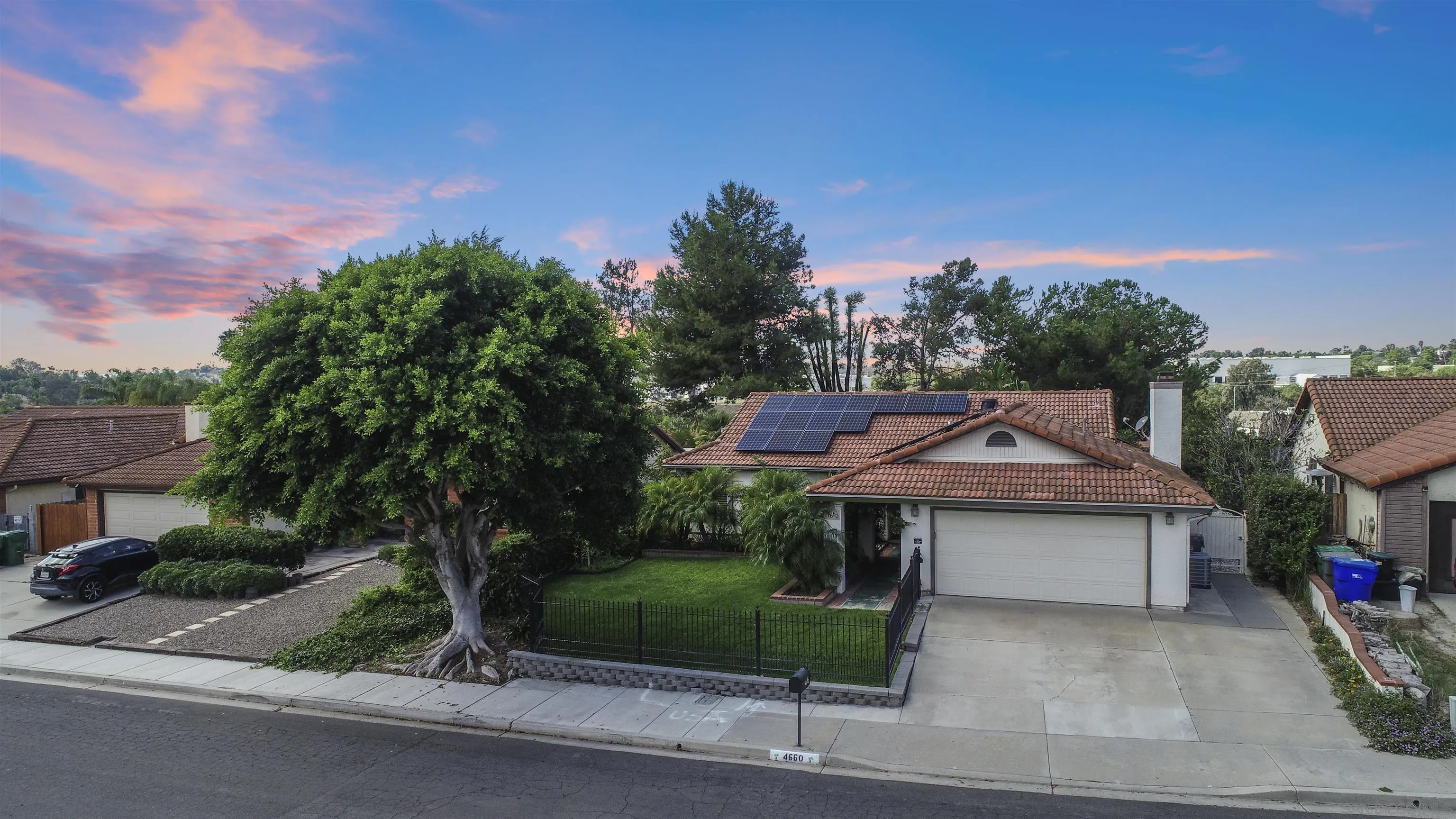 4660 Lofty Grove Drive Oceanside, CA 92056 - Photo 5 of 22 a view of a house with a yard and table and chairs under an umbrella