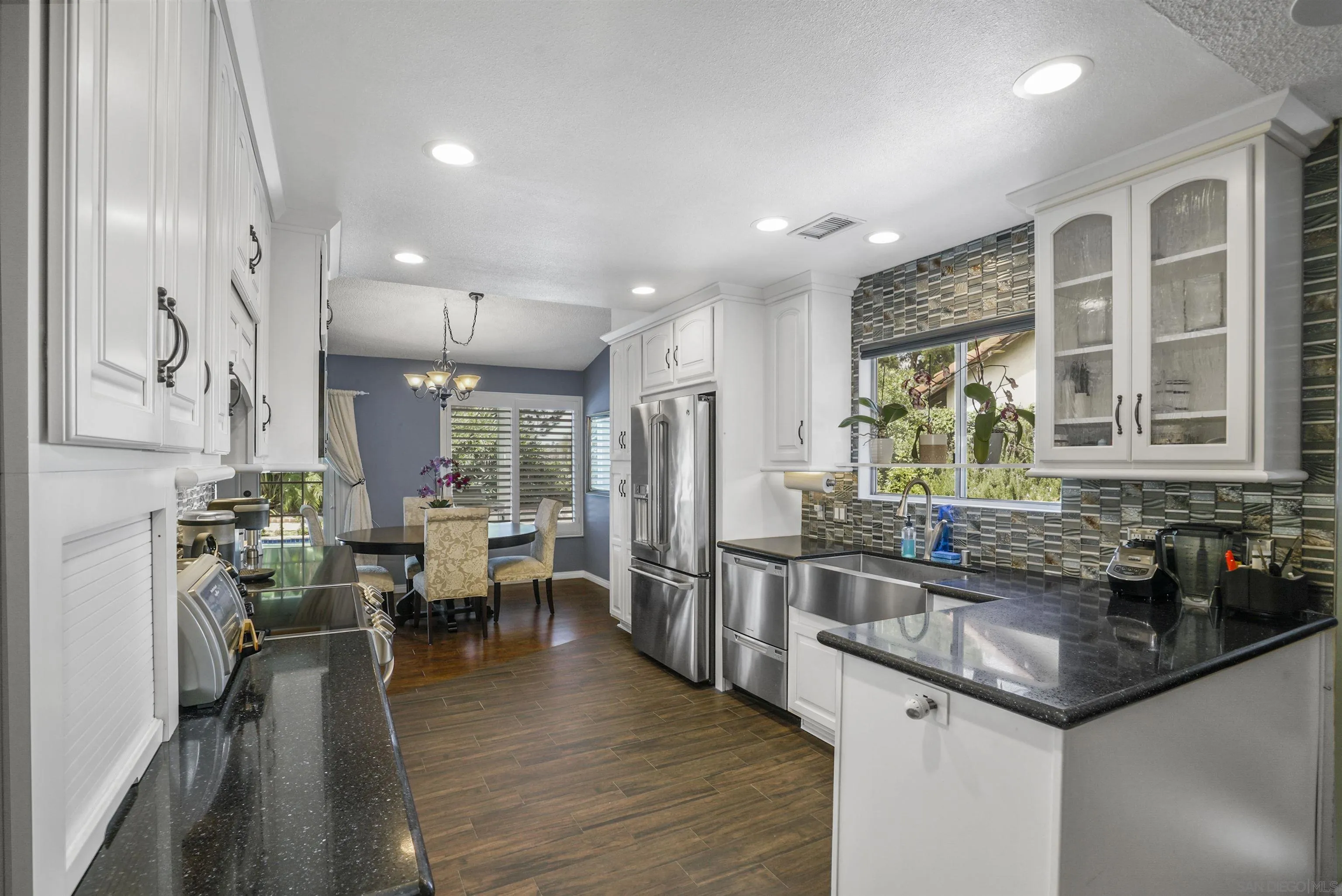 4660 Lofty Grove Drive Oceanside, CA 92056 - Photo 10 of 22 a kitchen with stainless steel appliances granite countertop sink stove and wooden floor