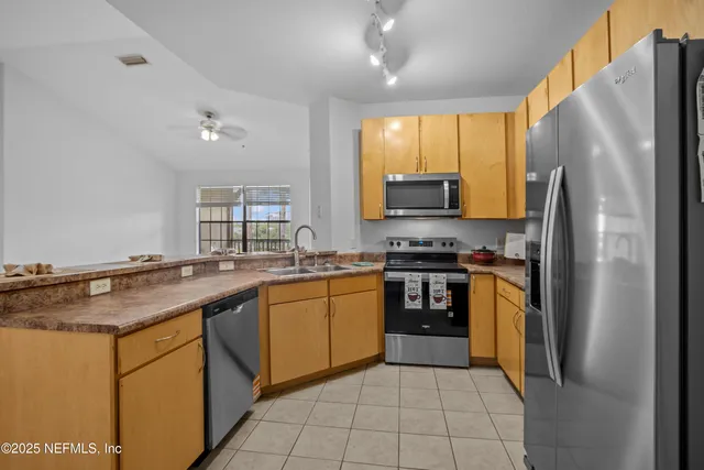 a kitchen with granite countertop a refrigerator stove top oven and sink