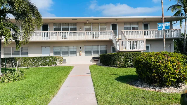 a front view of a residential apartment building with a yard