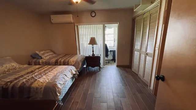 a bedroom with two beds and wooden floor