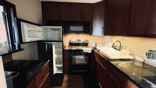 a kitchen with granite countertop stainless steel appliances and wooden cabinets