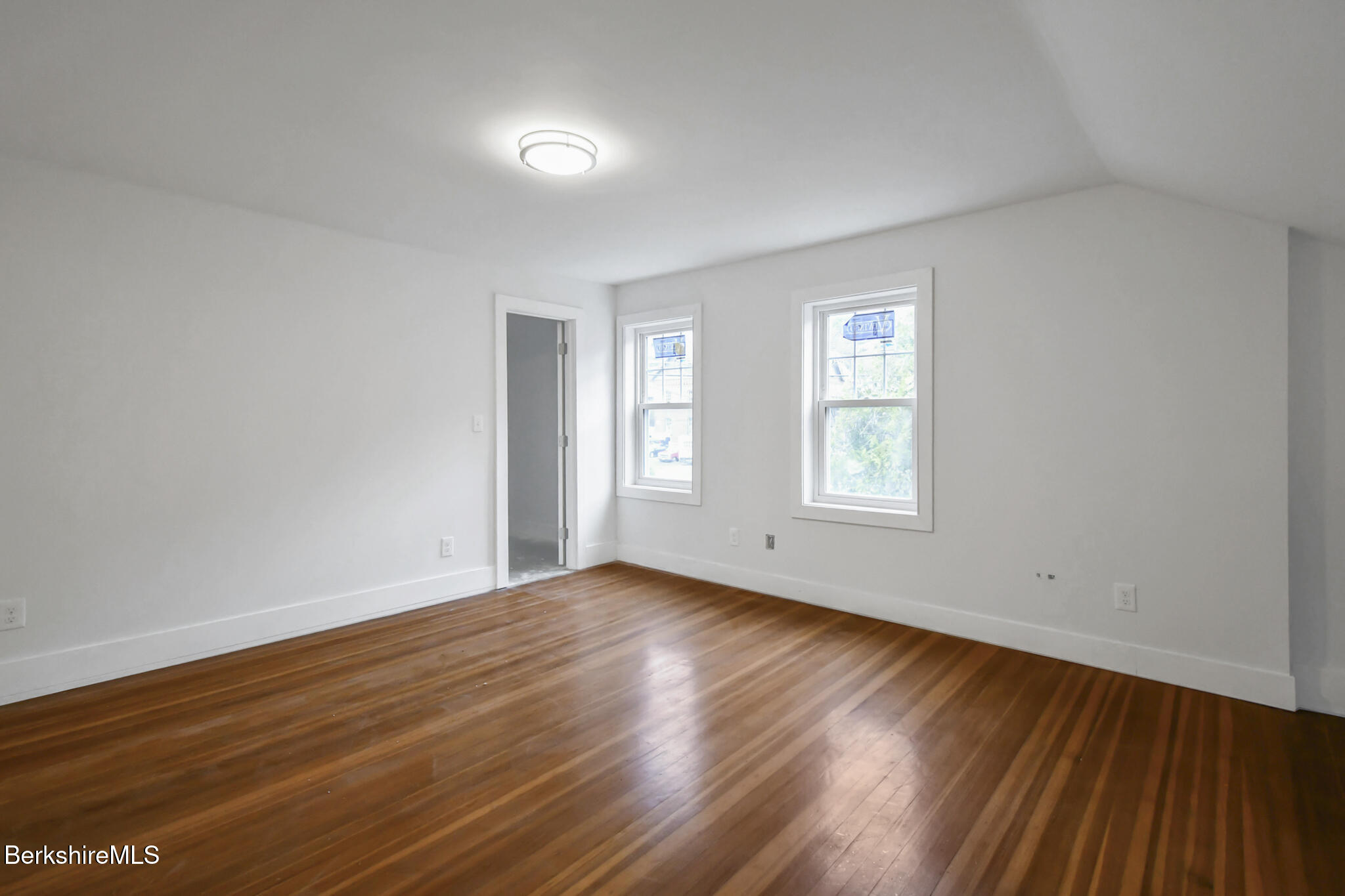 111 Columbia Street Adams, MA 01220 - Photo 4 of 33 a view of an empty room with wooden floor and window
