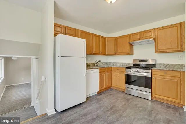 a kitchen with granite countertop white cabinets and white appliances