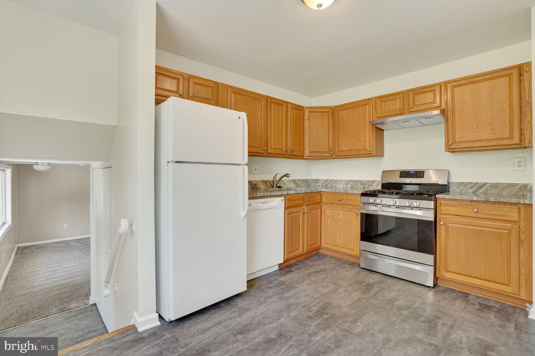 7720 Loudon Drive Fort Washington, MD 20744 - Photo 6 of 28 a kitchen with granite countertop white cabinets and white appliances