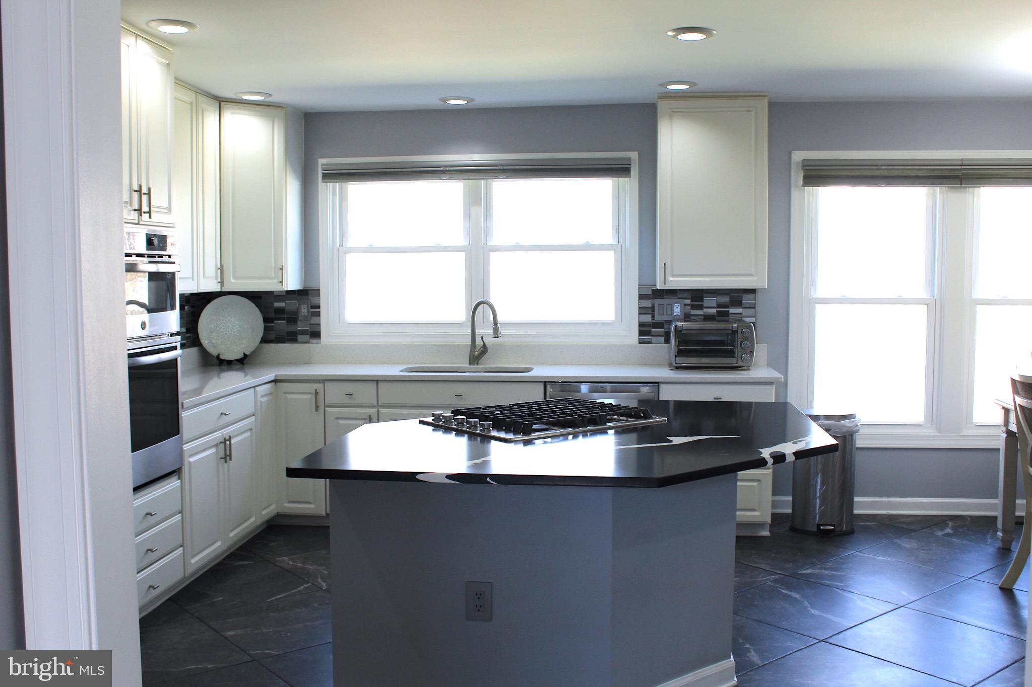 11546 Waesche Drive Bowie, MD 20721 - Photo 6 of 21 a kitchen with granite countertop a sink and a stove top oven
