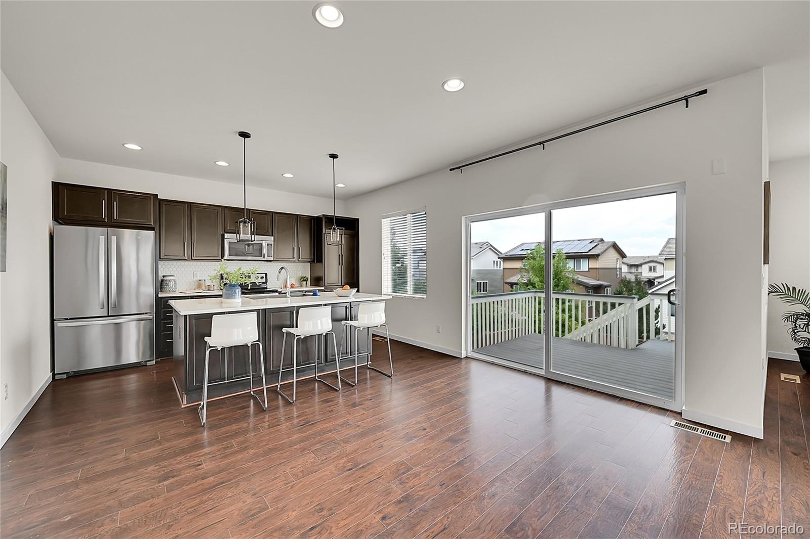 10951 Touchstone Loop Parker, CO 80134 - Photo 14 of 46 a kitchen with a table chairs refrigerator and microwave