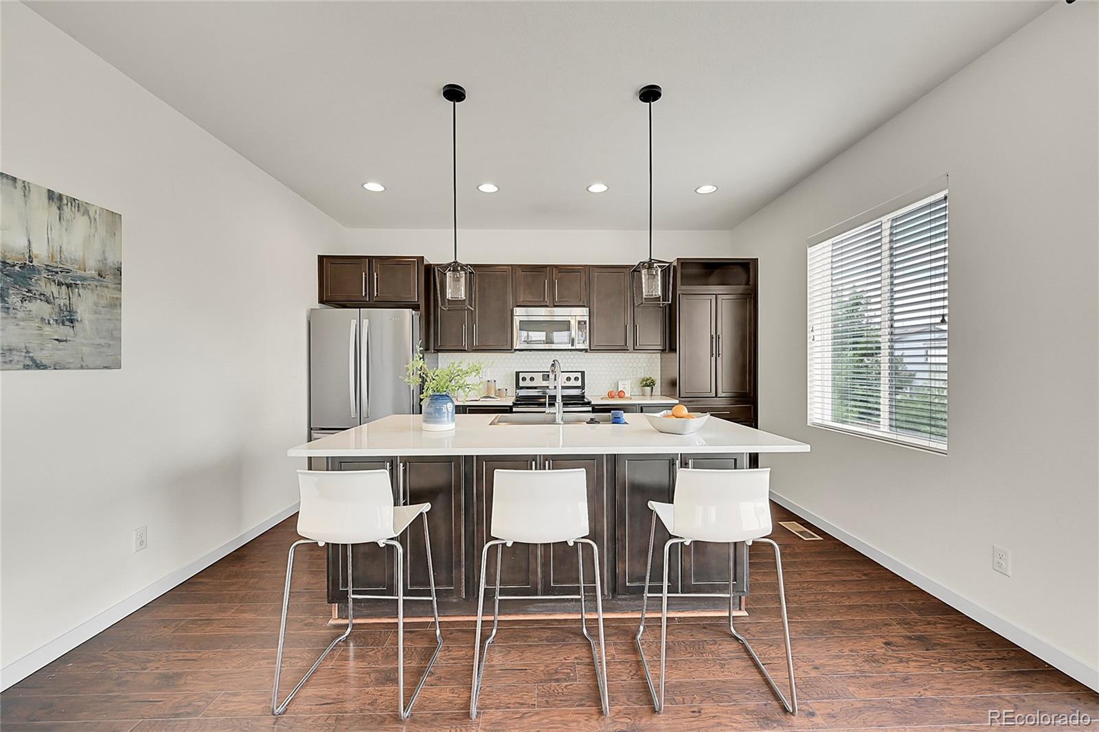 10951 Touchstone Loop Parker, CO 80134 - Photo 15 of 46 a kitchen with a dining table chairs and wooden floor