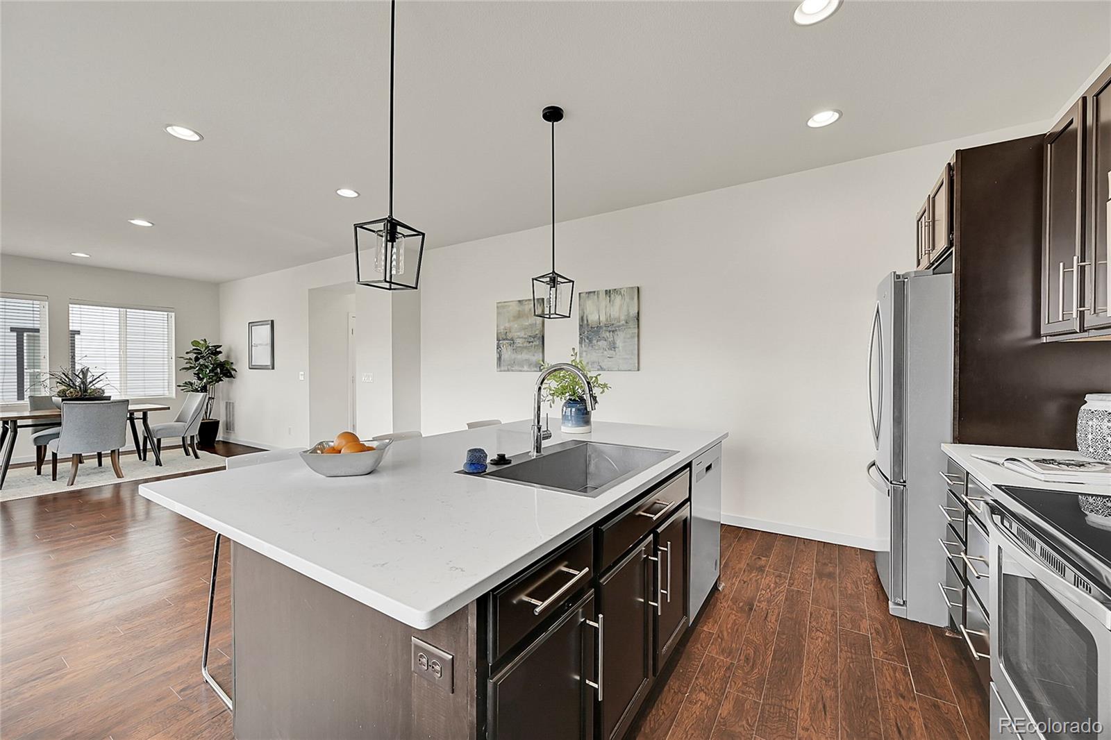 10951 Touchstone Loop Parker, CO 80134 - Photo 17 of 46 a kitchen with stainless steel appliances a sink a stove a refrigerator and a center island