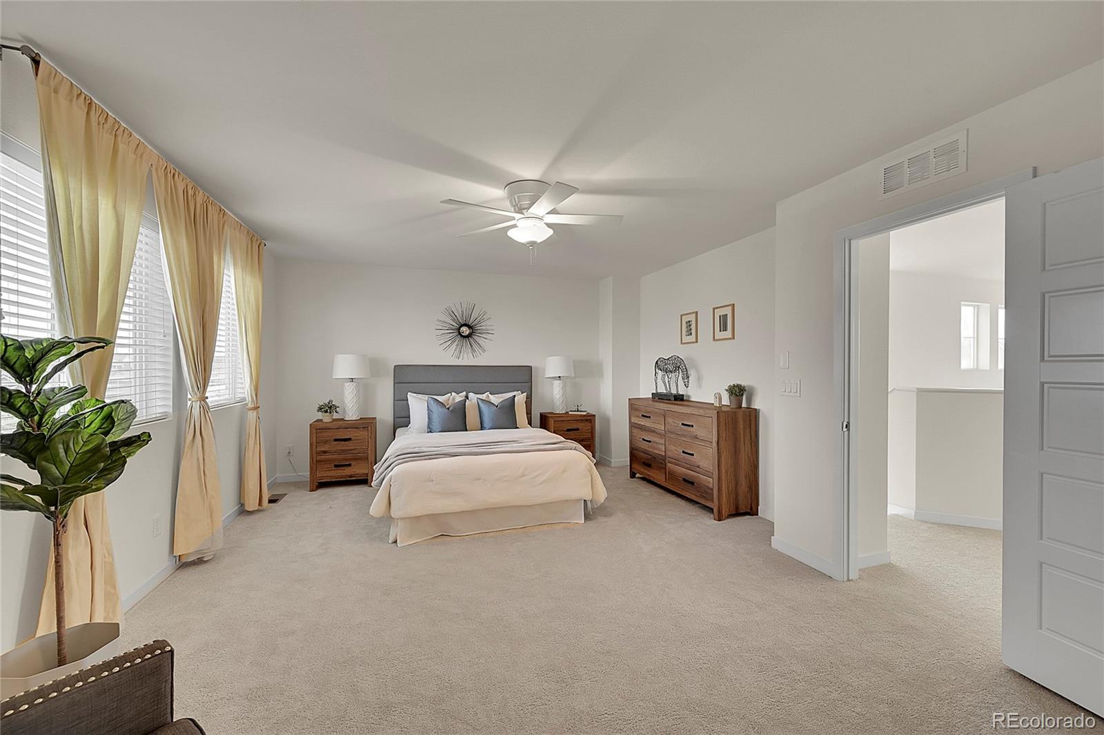 10951 Touchstone Loop Parker, CO 80134 - Photo 21 of 46 a spacious bedroom with a bed and a chandelier