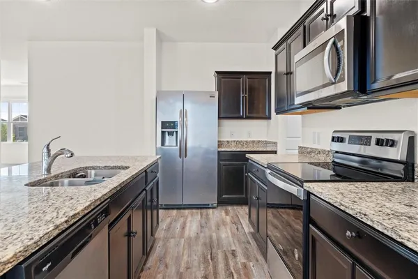 a kitchen with stainless steel appliances granite countertop a sink stove and refrigerator