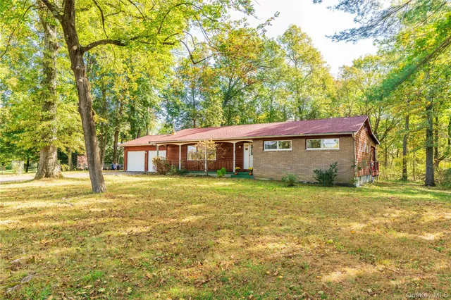 a view of a yard in front of a house with large trees
