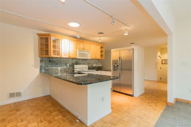a kitchen with stainless steel appliances granite countertop a sink and a refrigerator