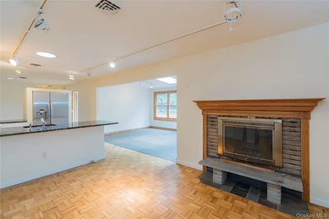 a view of an empty room with a fireplace and a window