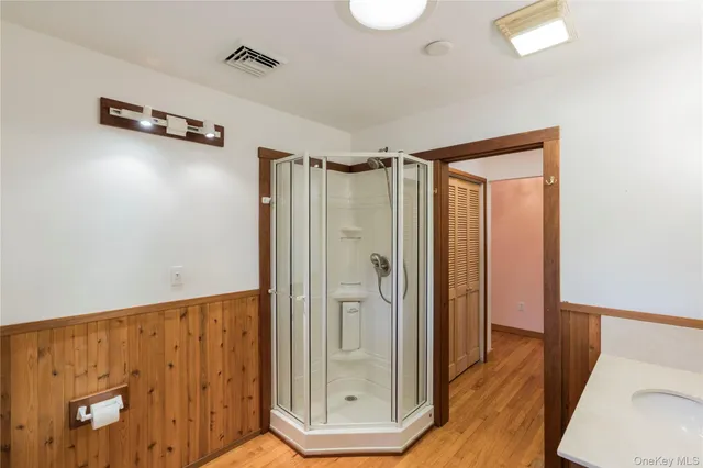 a view of a bathroom with wooden floor and mirror