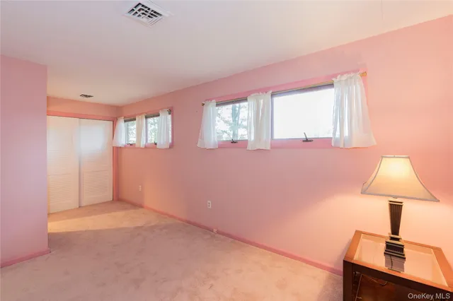 a view of an empty room with window and a kitchen