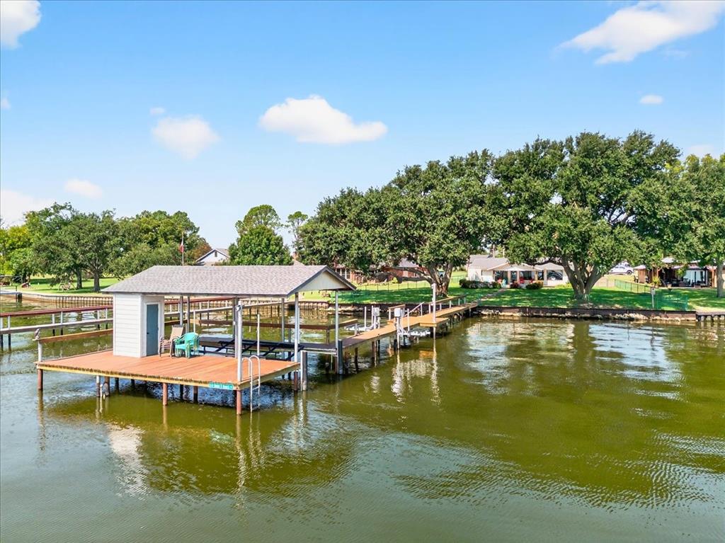 a view of an ocean with boats and trees in the background