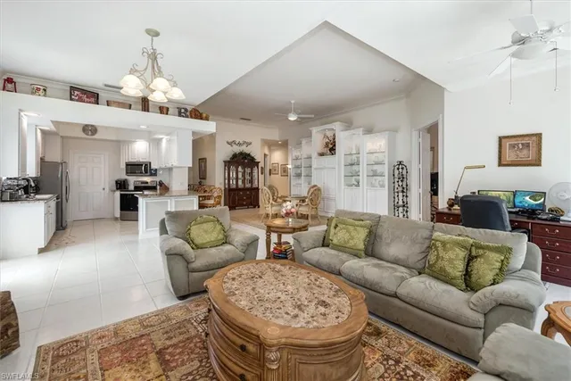 a living room with furniture kitchen view and a chandelier