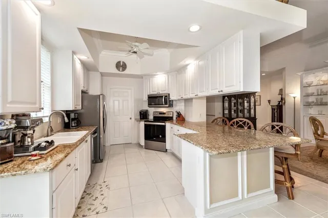 a kitchen with stainless steel appliances granite countertop a sink stove refrigerator and cabinets