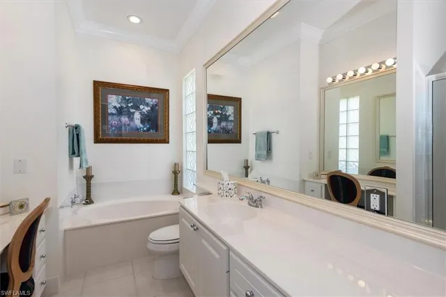 a bathroom with a toilet a sink a tub and mirror