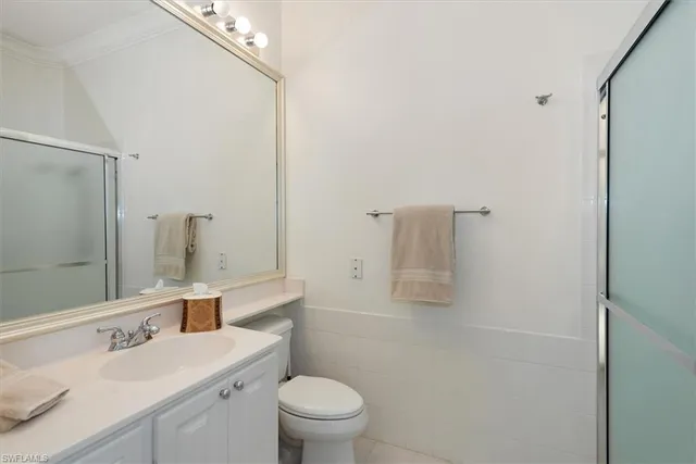 a bathroom with a sink toilet vanity and shower